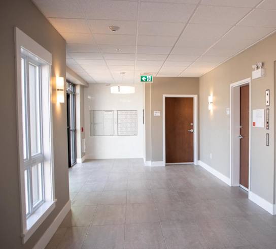 a large hallway with doors and windows in a hospital