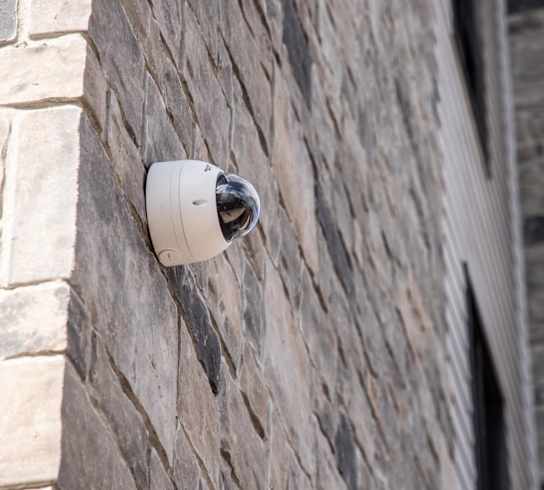 a security camera on the side of a brick building
