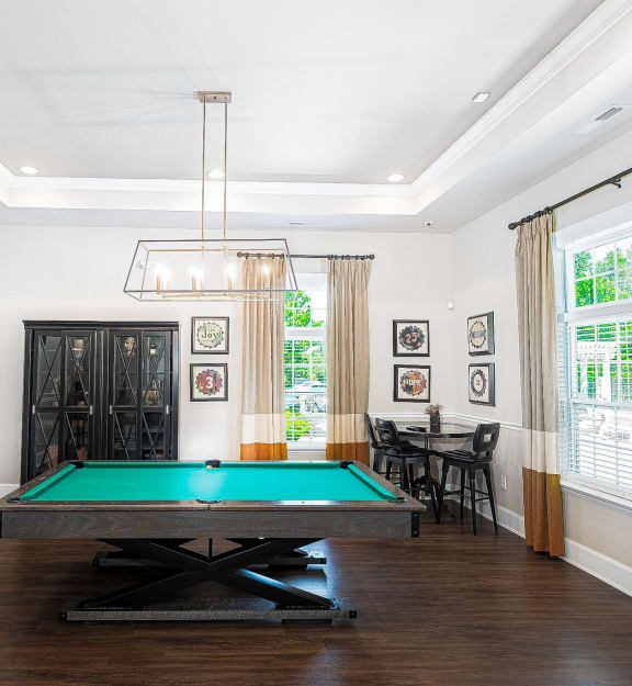 a living room with a pool table and a chandelier