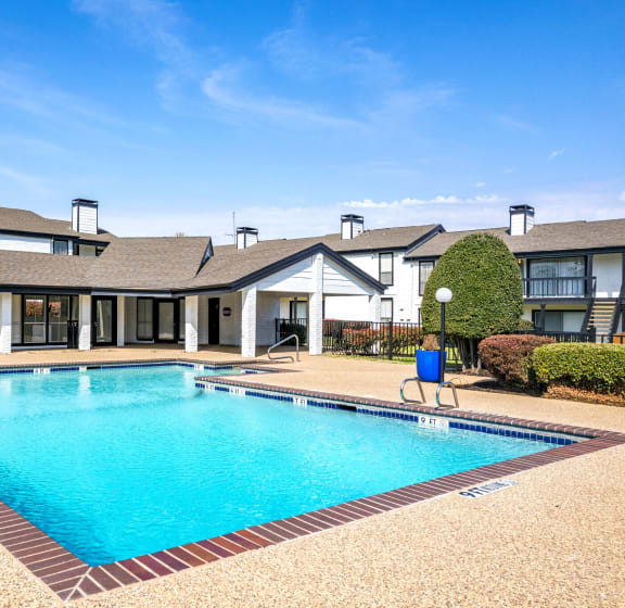a swimming pool with a building in the background at Keller Oaks, Carrollton, TX 75006