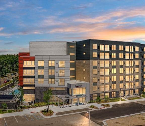 a large hotel building with a sunset in the backgroundat Beekman on Broadway, Ann Arbor, MI, 48105