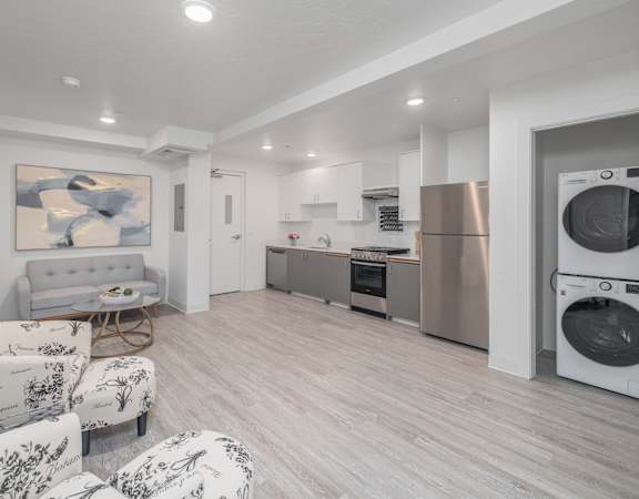 A modern kitchen with a washing machine and dryer built into the cabinetry.