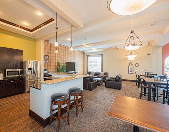 a kitchen with a bar and a living room with a table and chairs