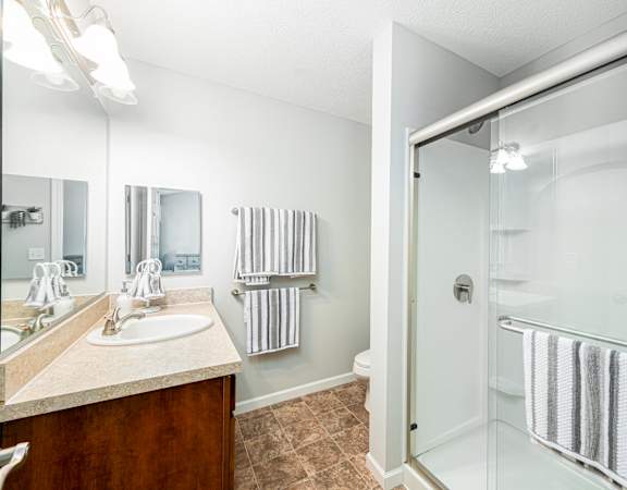 a bathroom with a shower and a sink and a mirror