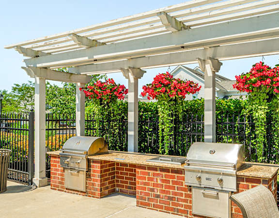 a patio with a barbecue grill and a pergola