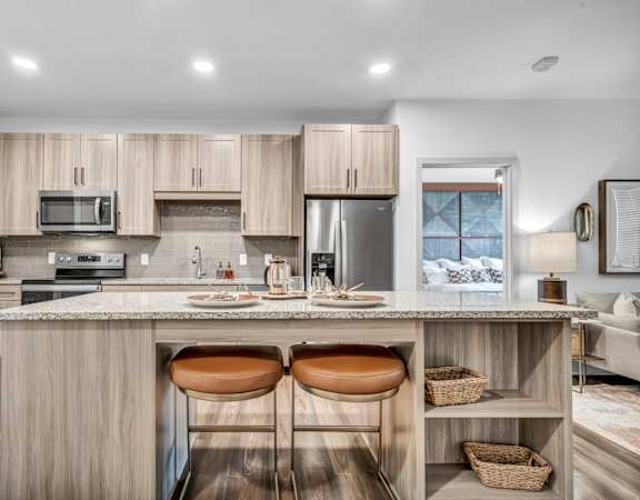 A modern kitchen with a bar stool in the middle.