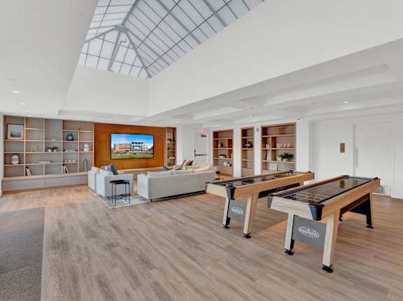 A room with a pool table and a foosball table.