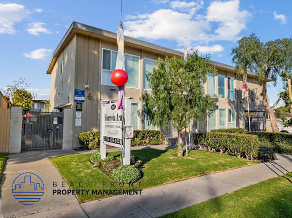 A building with a sign that says "Beach Front Property Management" in front of it.