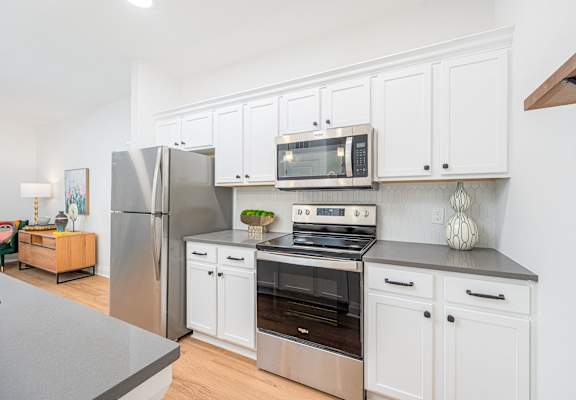 a kitchen with stainless steel appliances and white cabinets