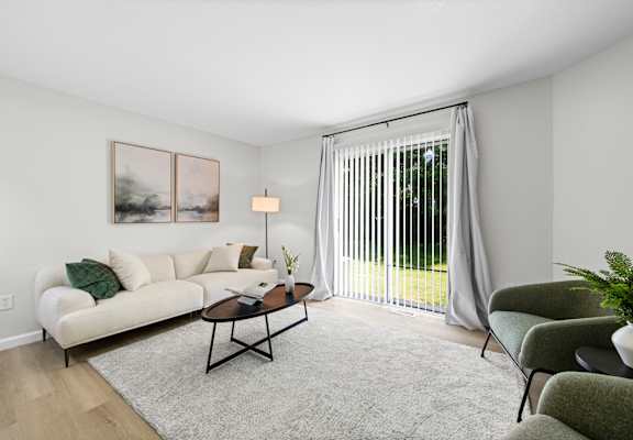 A living room with a white couch, a coffee table, and a painting on the wall.
