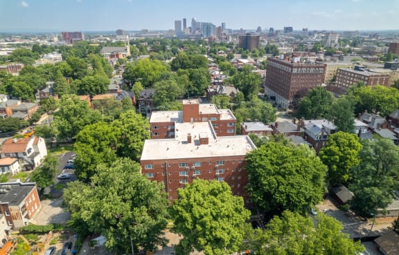 an aerial view of a brick building with trees in the foreground and the philadelphia skyline in