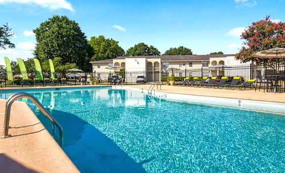 A swimming pool with a metal ladder and a metal fence.
