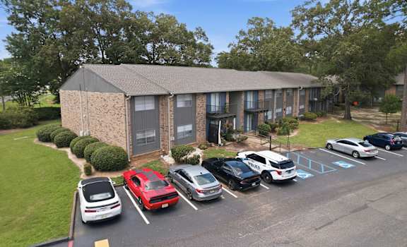 A parking lot with cars and a building in the background.