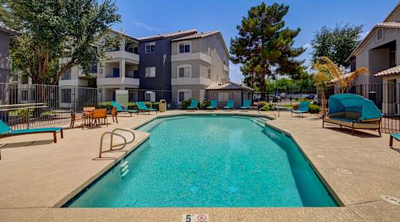 our apartments have a large swimming pool with chairs and umbrellas