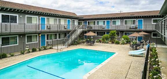a swimming pool in front of a hotel with a pool