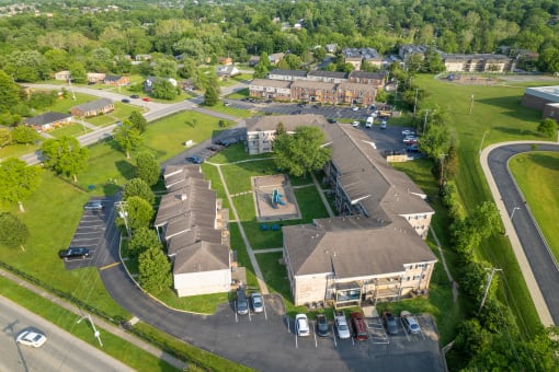 an aerial view of a large building with a basketball court in the middle of a grassy