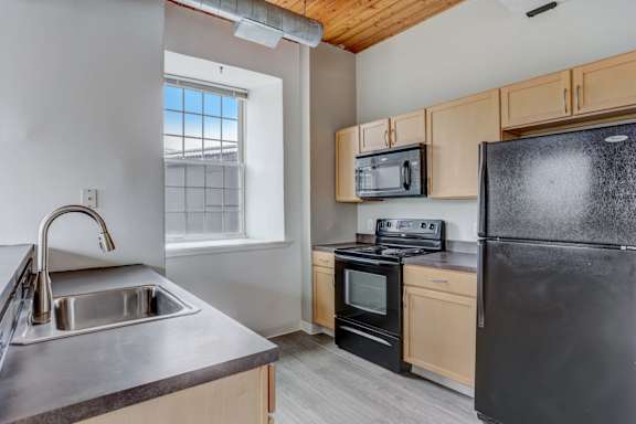 an empty kitchen with a sink and a refrigerator