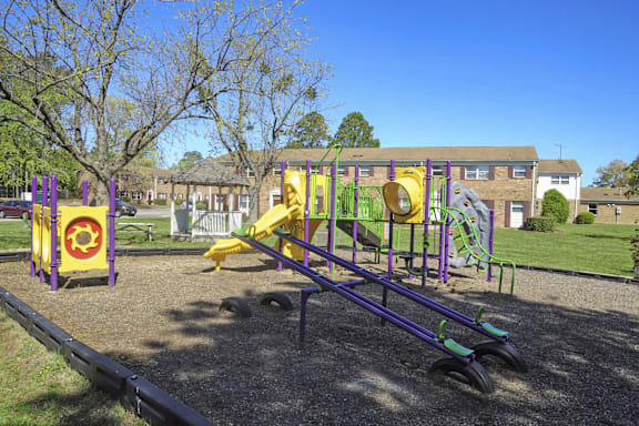 A playground with a purple slide and a yellow slide.