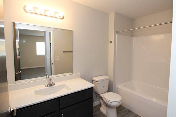A bathroom with a white sink, toilet, and bathtub.