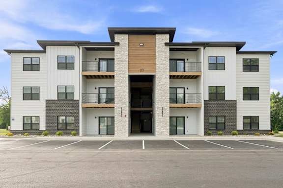A modern apartment building with a car parked in front.