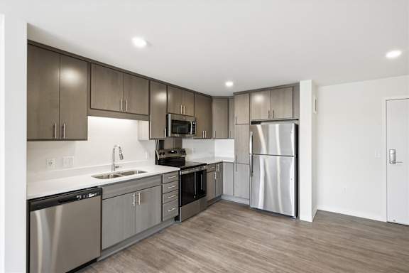 A modern kitchen with stainless steel appliances and wooden cabinets.