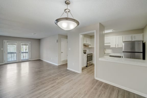 an empty living room and kitchen with an open floor plan at Hills at Hoover Apartments