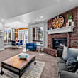 a living room with a brick fireplace and a large clock on the wall  at Eagles Landing, Ammon, ID