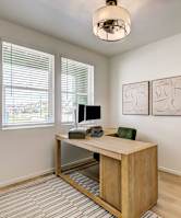 A room with a desk and a plant.