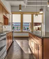 A modern kitchen with wooden cabinets and stainless steel appliances. at 100 South Apartments, New York 14202
