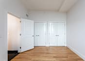 Thumbnail 21 of 23 - Three white doors in a room with wooden floors.