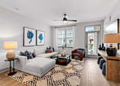 Thumbnail 15 of 19 - A living room with a grey couch, a coffee table, and a rug.