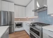Thumbnail 4 of 27 - Kitchen with White Cabinetry and Stainless Steel Appliances