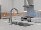Thumbnail 24 of 27 - Kitchen with White Cabinetry and Stainless Steel Appliances