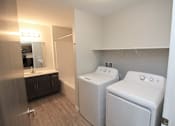 Thumbnail 6 of 14 - A bathroom with a washer and dryer in it.