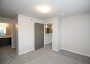 Thumbnail 10 of 14 - A large, empty room with a carpeted floor and white walls.