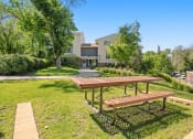 Thumbnail 1 of 57 - a picnic table in a park with a house in the background