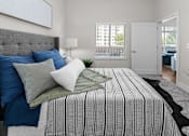 Thumbnail 9 of 10 - A bedroom with a large bed and a grey headboard.