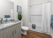 Thumbnail 8 of 8 - A bathroom with a white toilet, a sink, and a shower.