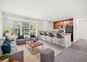 Thumbnail 1 of 8 - A living room with a grey sofa and a coffee table.