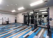 Thumbnail 4 of 26 - A gym with a blue and brown floor at AVIA Lofts on Victors Way, Ann Arbor Michigan