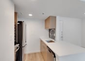 Thumbnail 3 of 12 - Kitchen with white counter top and refrigerator at AVIA Apartments On Alpha, Dallas, TX, 75240