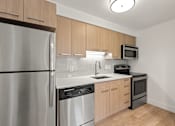 Thumbnail 22 of 29 - Kitchen with granite counter, sink and fridge at AVIA Lofts on Parkway, Washington , 98662