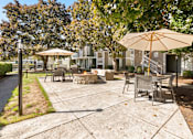 Thumbnail 5 of 15 - a patio with tables and umbrellas in front of a house at AVIA Lofts on Parkway, Vancouver