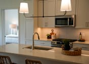 Thumbnail 8 of 8 - A kitchen with a white counter top and a sink.