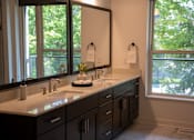 Thumbnail 3 of 8 - A bathroom with a large mirror and a sink with a white counter top.