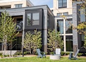 Thumbnail 4 of 8 - A modern building with a glass facade and a green lawn in front.