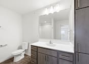 Thumbnail 22 of 22 - A bathroom with a white toilet, sink, and mirror.