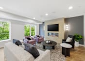 Thumbnail 5 of 22 - A modern living room with a grey couch and a fireplace.