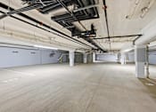 Thumbnail 10 of 22 - A large, empty warehouse with a concrete floor and white walls.