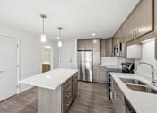 Thumbnail 20 of 22 - A modern kitchen with a white countertop and stainless steel appliances.
